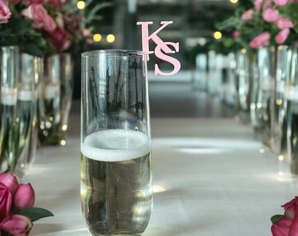 Pink custom wedding drink topper with elegant design, close-up shot on cocktail glass.