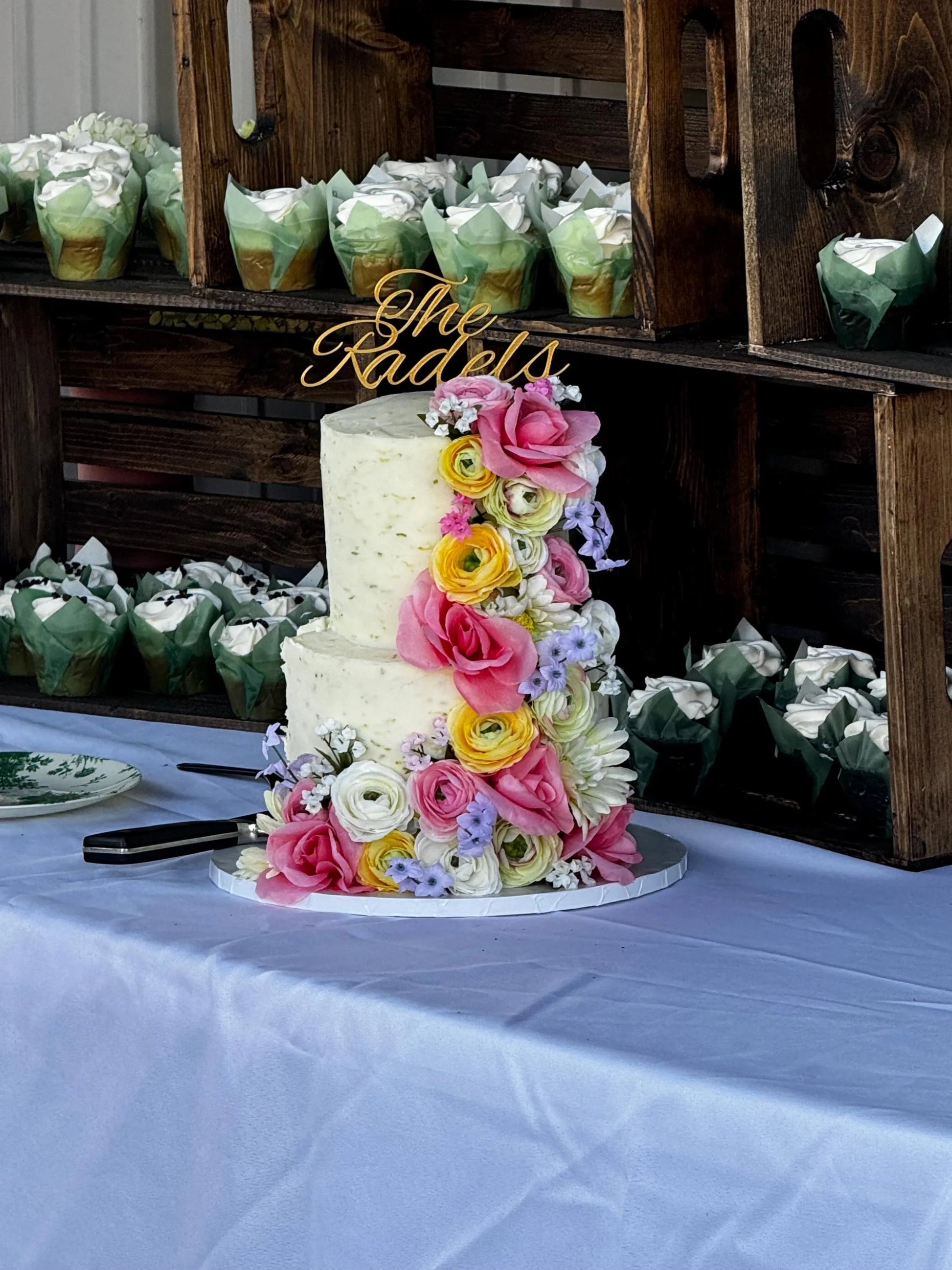 Personalized wedding cake topper featuring custom names and wedding date on a beautifully decorated cake.